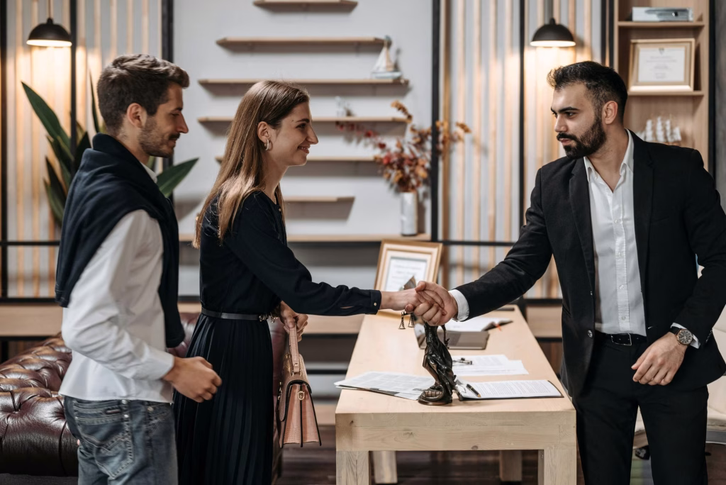 couple shaking hands with family lawyer